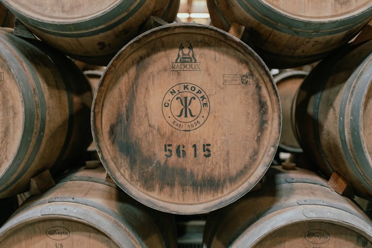 Wooden wine barrels aging in a traditional cellar in Porto, Portugal.